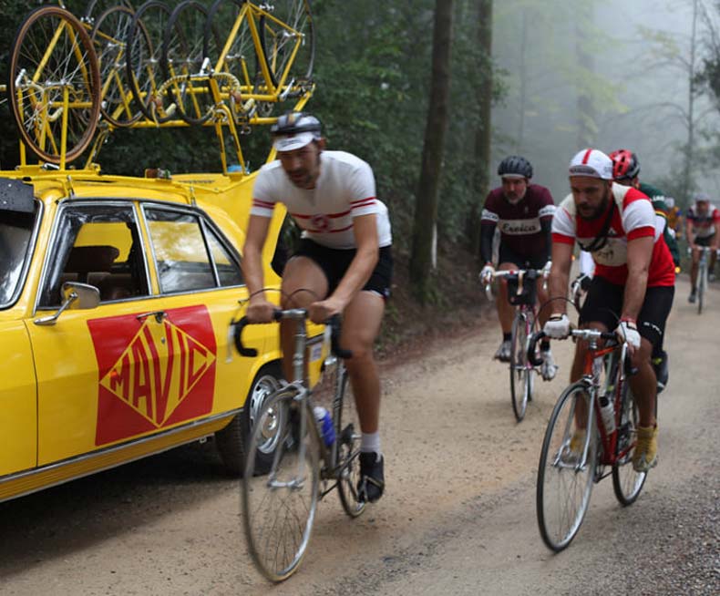 Cyclists at L'Eroica riding past the Mavic team car