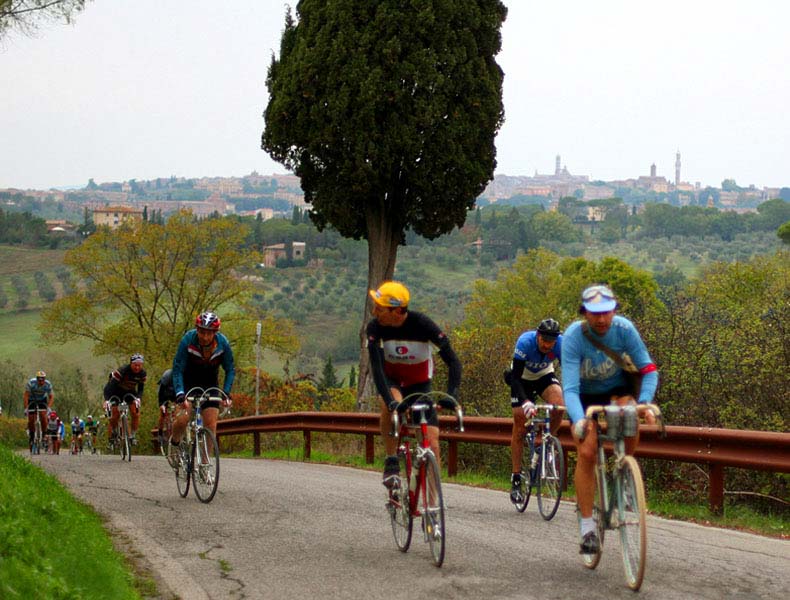 Riders cycling up a hill on the outskirts of Siena