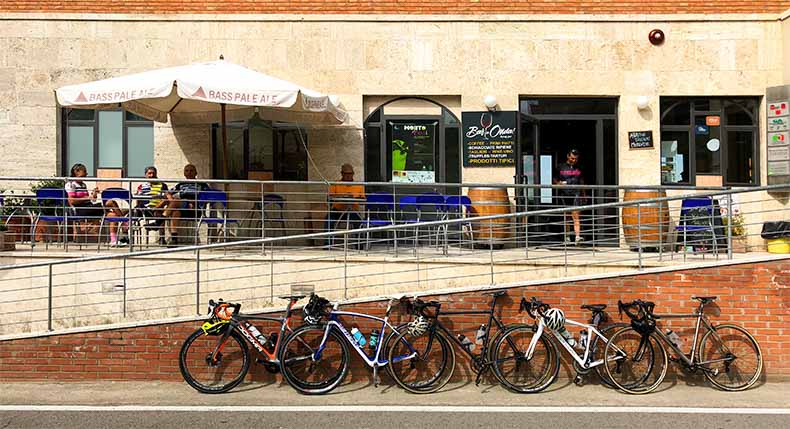 Bicycles lined against a wall while cyclist stop for a mid ride coffee
