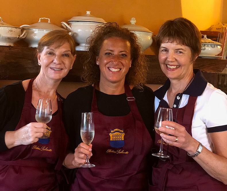 three women having a glass of wine during a cooking class in Tuscany