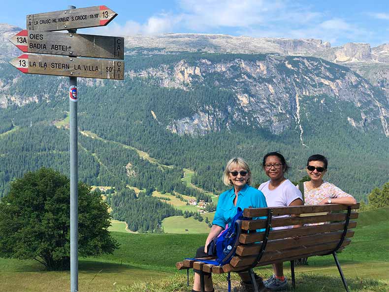 Non riding partners taking a break mid hike to enjoy the view of the dolomites