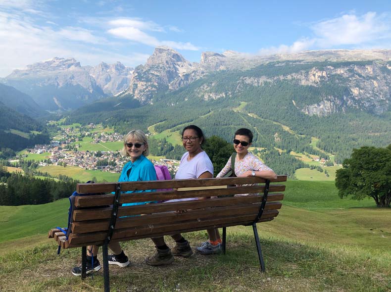 Three non riding partners taking a mid hike break to take inthe view of the Dolomites