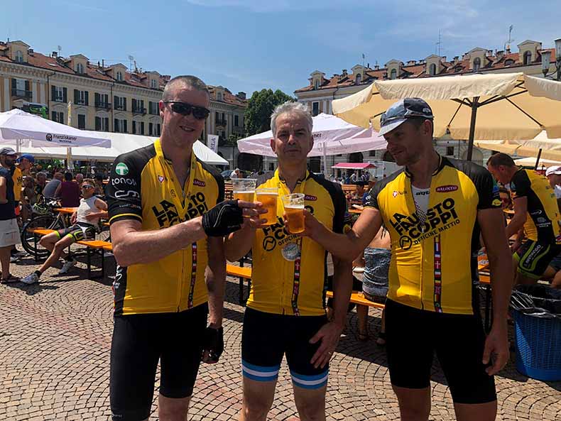 Three cyclists drinking a celebratory beer at the end of the La Fausto Coppi Gran Fondo