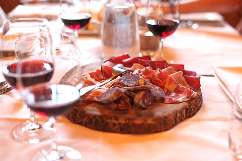 glasses of red wine and a Salumi board in Italy