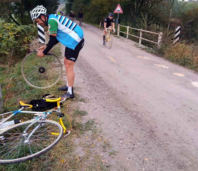 a man changing a flat tyre during L'Eroica