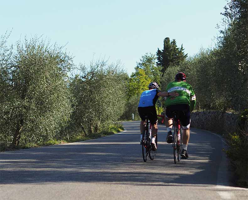 A rider giving another rider a hand up a hill