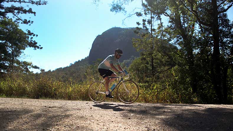 a man cycling on gravel in the countryside