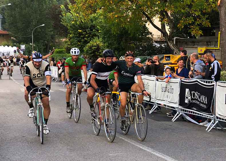 Two riders arm in arm finishing L'eroica