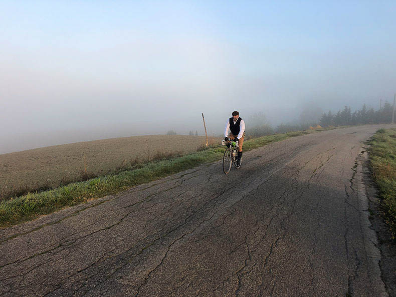 A man riding out of the fog during L'Eroica