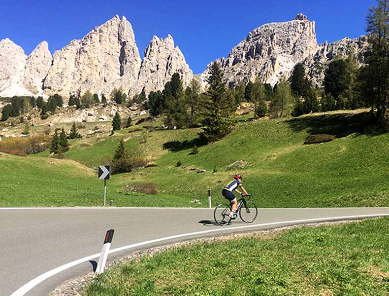 a woman cycling up to Passo Gardena
