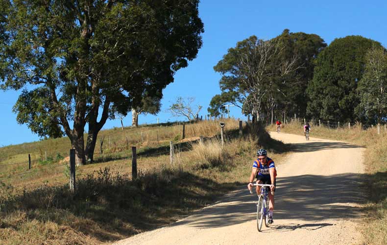 A cyclist descending on a gravel road in the country