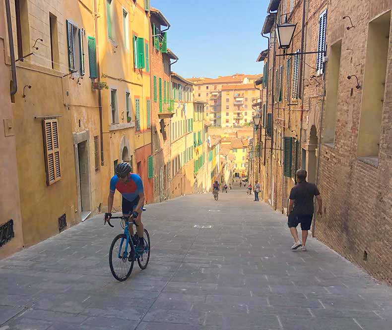 A cyclist riding up a hillin Siena
