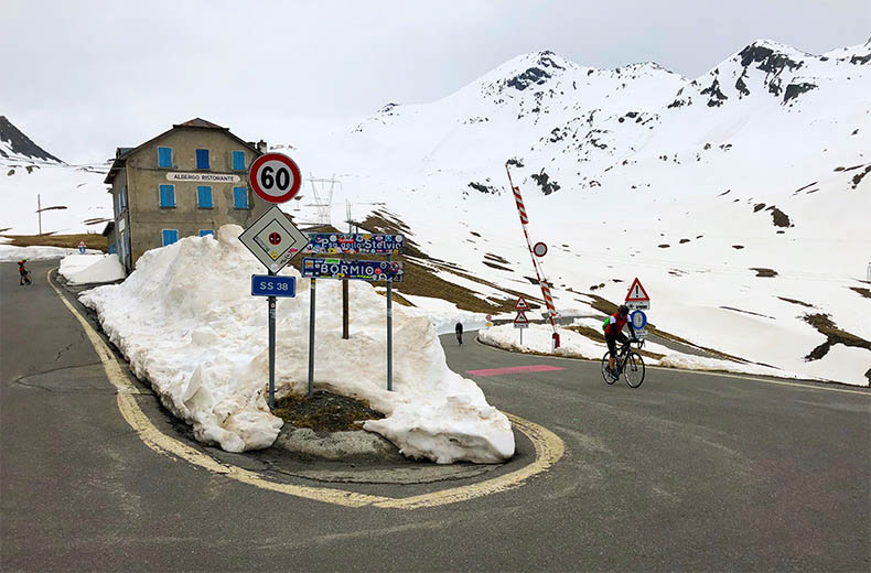 Cyclist riding to the top of Passo Dello Stelvio in the snow