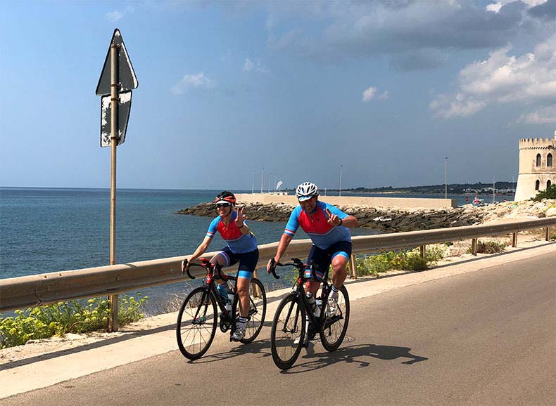 Two riders cycling along the coast on a cycling holiday in Puglia