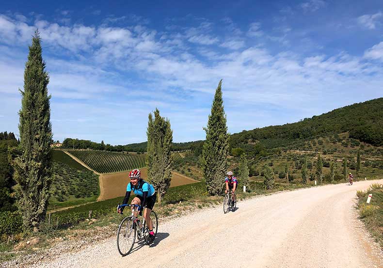 Two riders cycling on the gravel in Tuscany