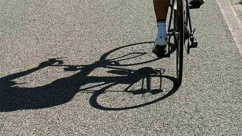 A shadow of a cyclist on the road