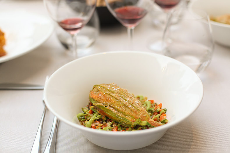 Glasses of wine and a bowl with a stuffed zucchini flower