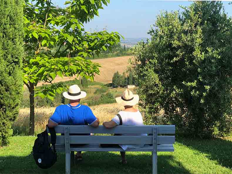 A couple sitting on a bench looking at the Tuscan Landscape