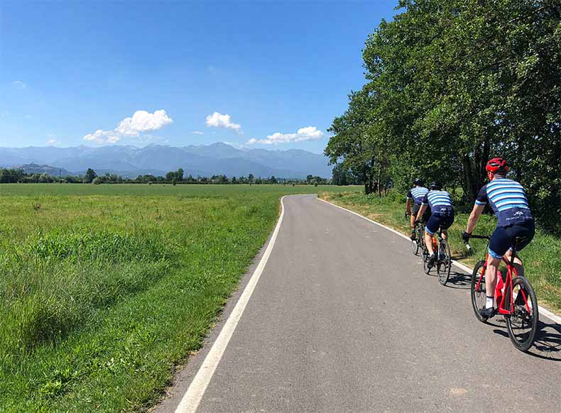 three cyclist riding towards the Alps