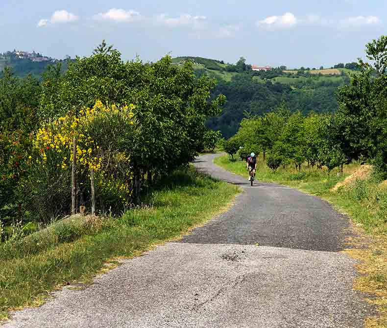 A man riding in the lush green landscape of Piemonte