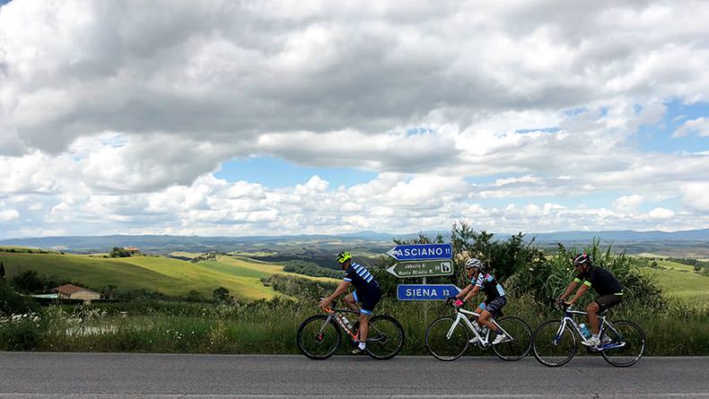 Three cyclist riding in the crete Sinese of Tuscany