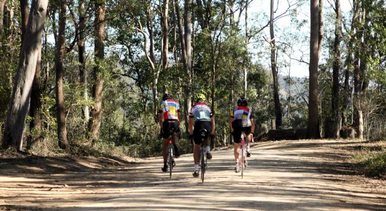 three cyclist on a gravel road