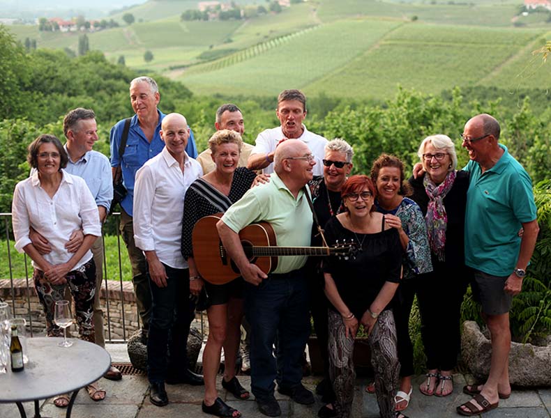 a group of people and a guitarist in le langhe