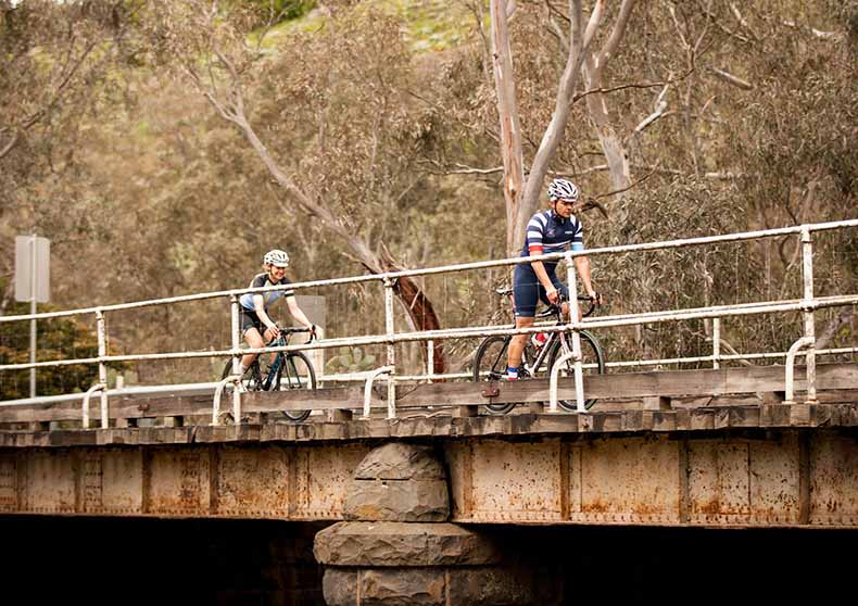 two riders cycling over a bridge near Daylesford