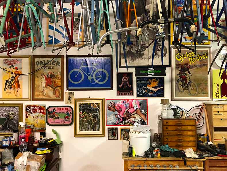 bicycle frams hanging from the roof and bicycles pictures on the walls