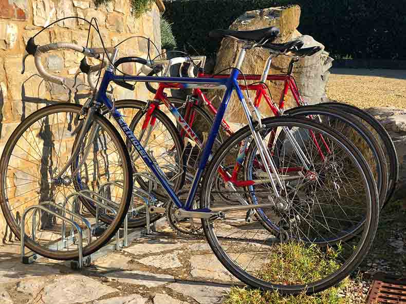 Vintage steel bikes against a stone wall in Tuscany