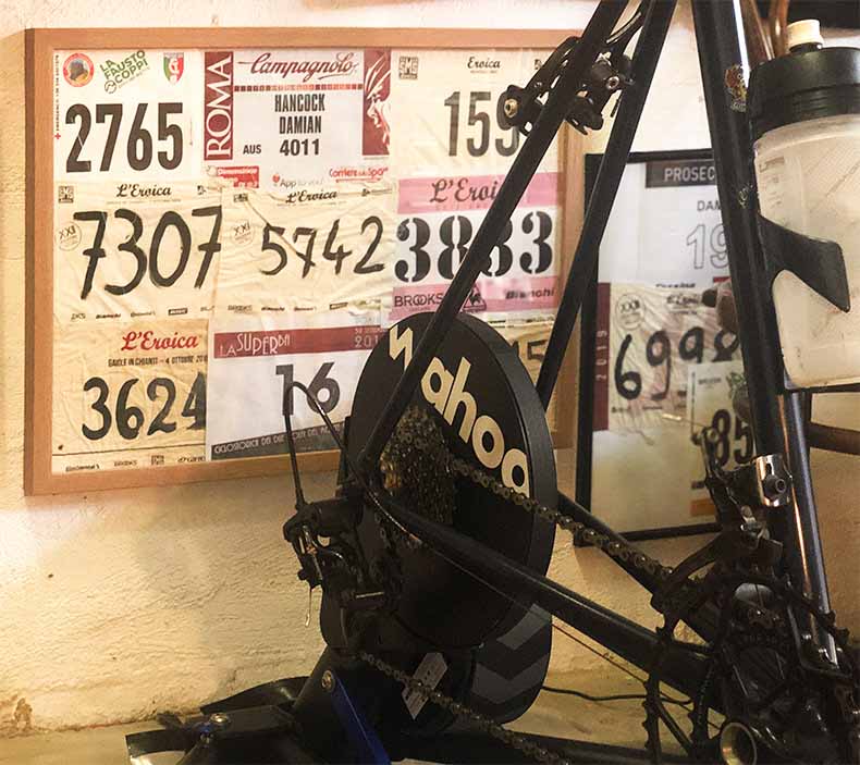 a wahoo kickr in front of a frame filled with Gran Fondo ride numbers