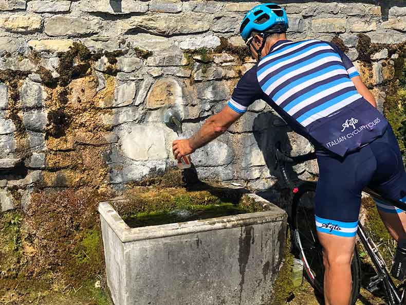 A cyclist filling his bottle up with water