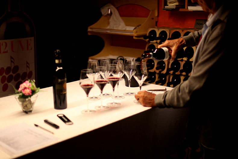 glasses being filled with red wine at a wine tasting in Tuscany