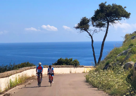 A couple riding by the sea in Puglia