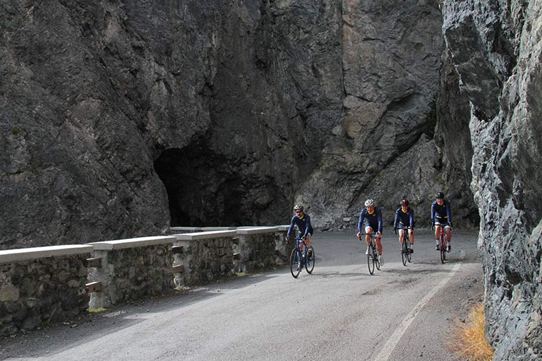 Four cyclists riding through the Cancano tunnel