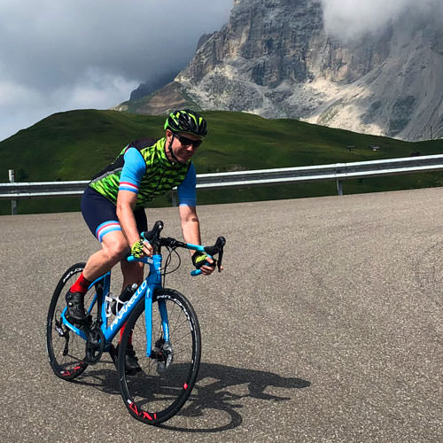 A man cycling down from Passo Sella in the Dolomites on a cycling holiday