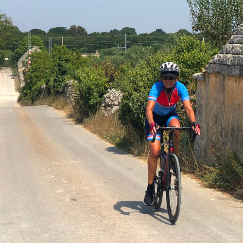 A lady riding a bike through Puglia on a cycling Holiday