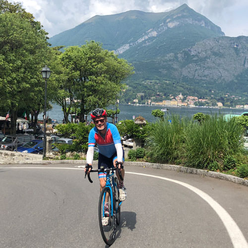 A man cycling away from Lake Como