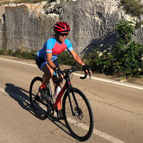 A woman cycling on holidays in Southern italy