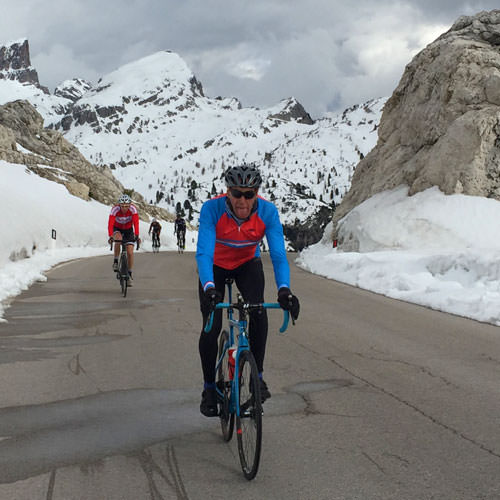 A man cycling up to Passo Valporola in the snow