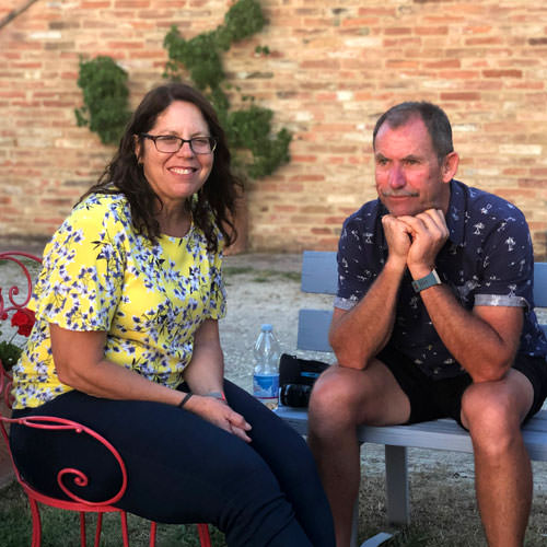 A man and woman watching the sun set over the Tuscan hills