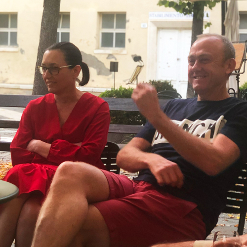 A man and a woman sitting in a piazza in Tuscany