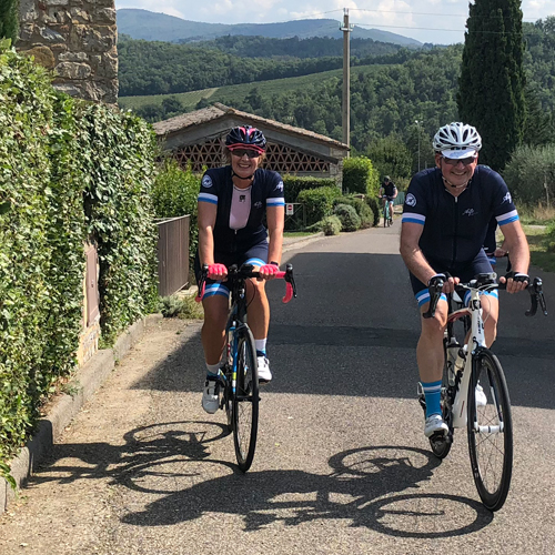 A man and a woman cycling in Gaiole in Chianti on a cycling holiday in Tuscany