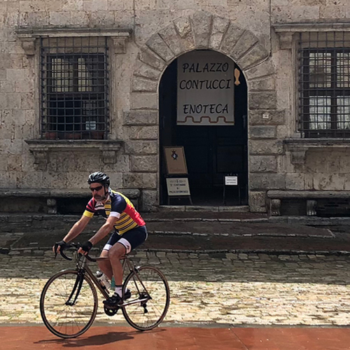 A man riding across a piazza in Italy