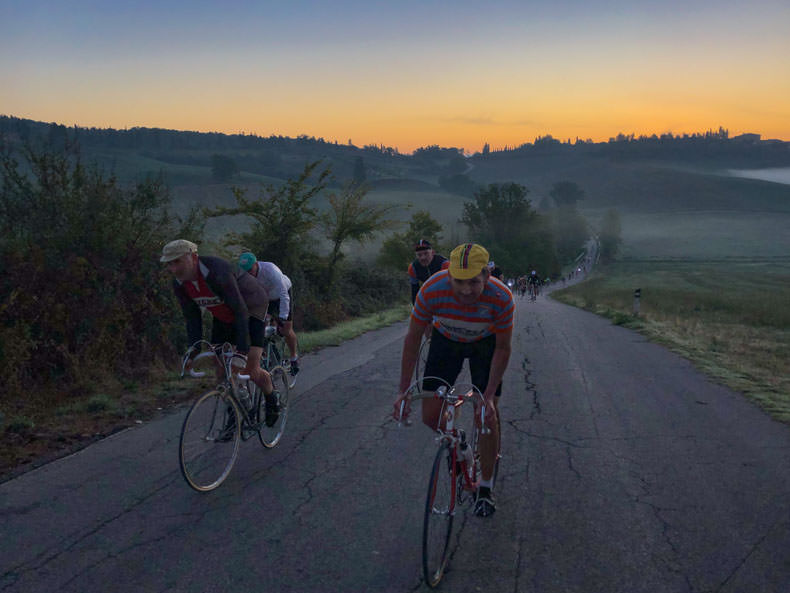 Cyclists at dawn riding L'eroica in Tuscany