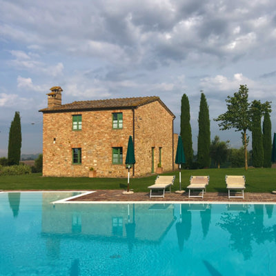 a pool and stone house in the tuscan countryside