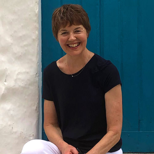 A lady sitting in front of a blue door